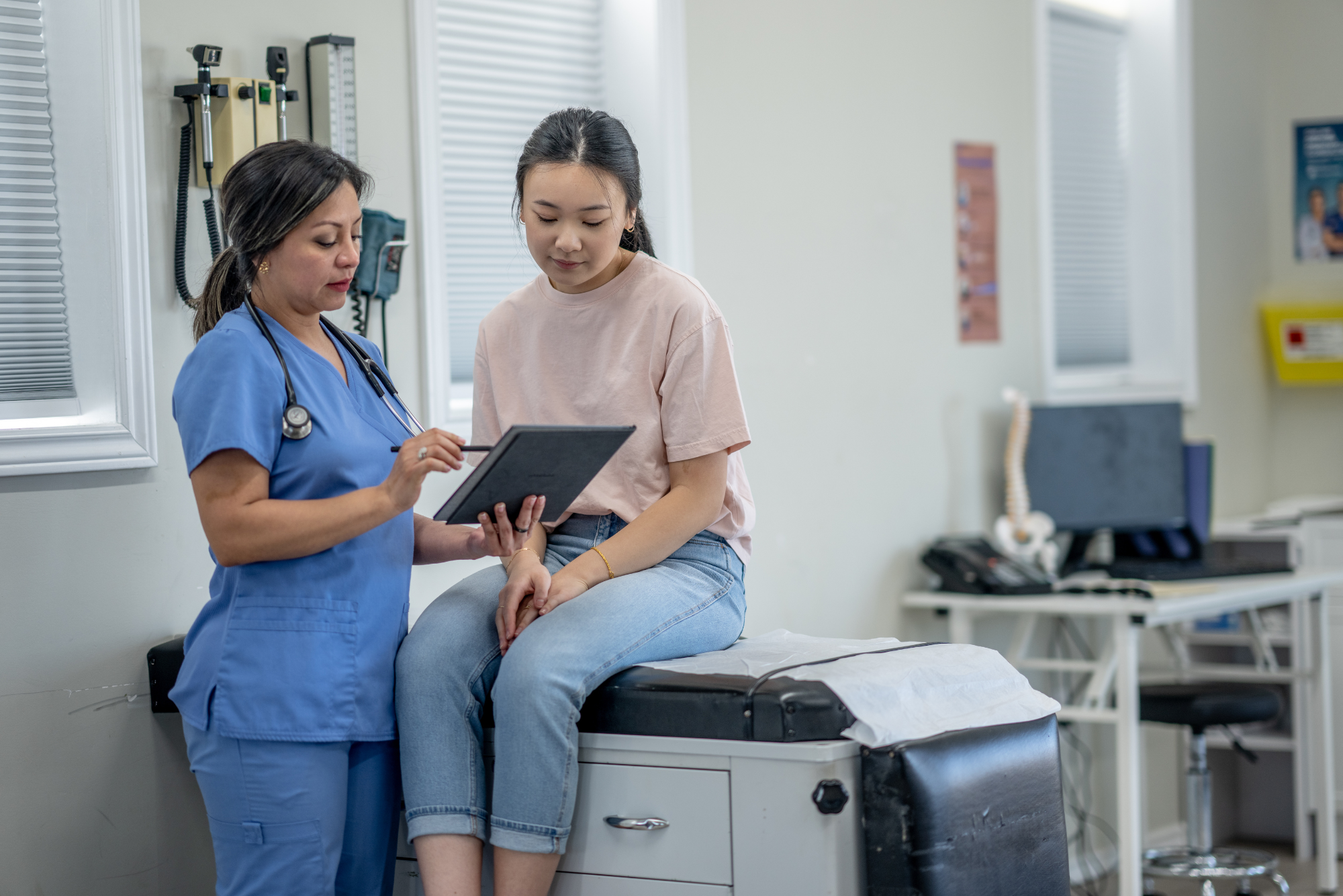 Medical professional assists patient with digital records during appointment.